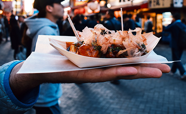 Man offering takoyaki street food in Osaka