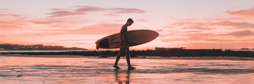 Surfer walking on beach